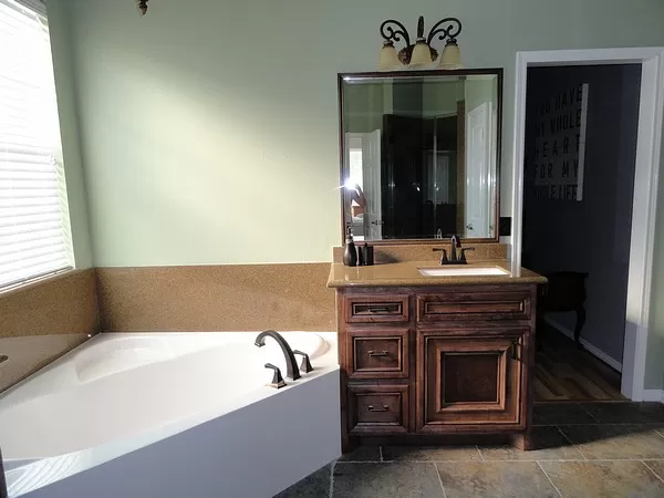 Bathroom Remodeling New White Tub and Dark Brown Vanity with Dark Granite Countertops and Backsplash. After of Before and After.Pictures.