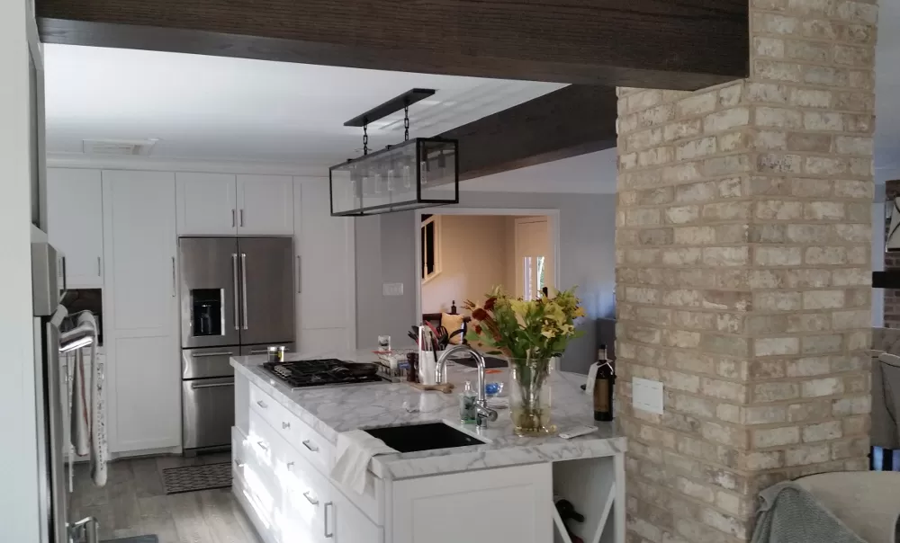 Island Kitchen with Light Grey Granite Countertops with seating for three, a New Gas Cooktop and a New Island Sink. New White Cabinets and Hardware. New Refrigerator